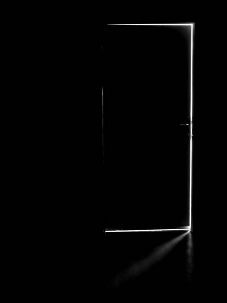 istock A dark door with a light behind it, light in the dark through an open door 1463341649