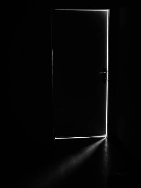 istock A dark door with a light behind it, light in the dark through an open door 1463341654
