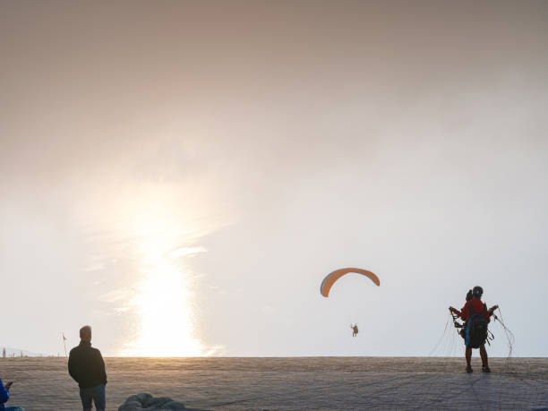 Paragliding in sky. Paraglider tandem flying over sea and mountains in cloudy day. view of paraglider and Blue Lagoon in Oludeniz, Turkey. Extreme sport. Landscape