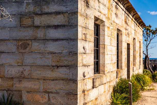 Old brick and stone building ruin with rusted iron jail bars.