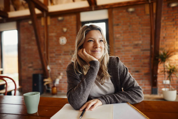 istock Smiling creative woman day dreaming at home office. 1463345535