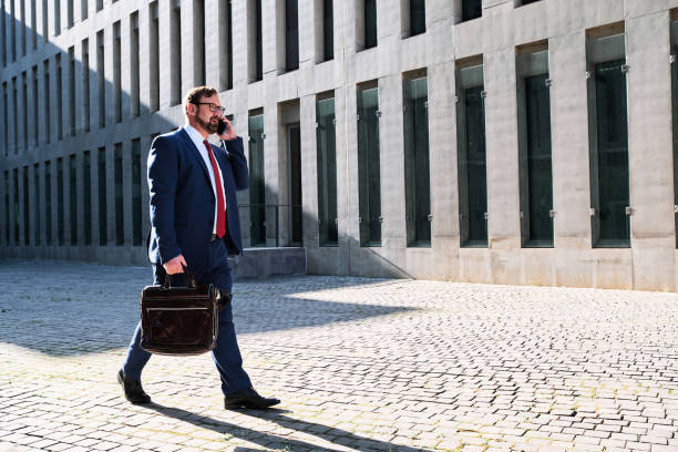 istock Businessman talking to the mobile while walking in the street 1463345770