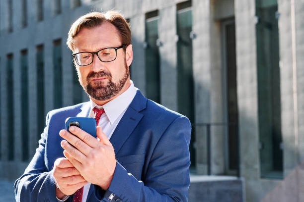 istock Concentrated businessman using the mobile outdoors 1463345793