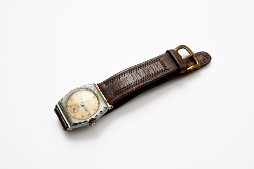 Close-up of Vintage Wristwatch with brown leather band on white background.