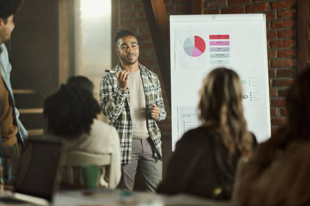 istock Black creative man leading a presentation in the office. 1463346381