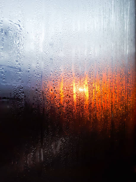 istock Water drops on a window glass with blurred beautiful sunset sky 1463347224