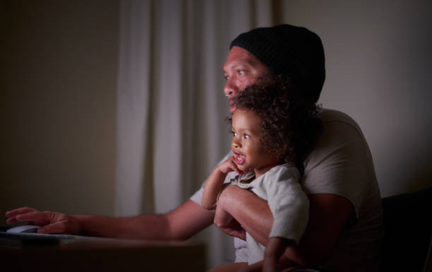 istock Father, baby and working on computer at night on project deadline in dark home office. Black family, pc and man, freelancer or remote worker work on report with infant, child or toddler in house. 1463347937
