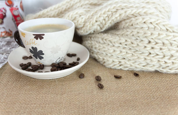 A cup of coffee with some coffee beans around it. Morning concept.