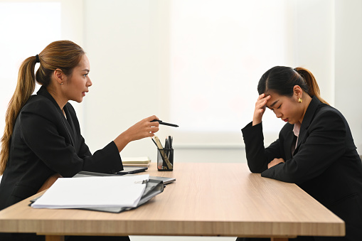 Furious female manager scolding frustrated interns. Emotional pressure, stress at work concept.