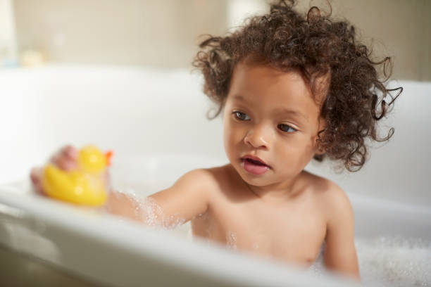 amusant, ludique et un bébé dans le bain avec des jouets pour jouer, nettoyer le corps et la routine. hygiène, concentration et enfant dans une bulle d’eau pour se laver, se baigner et nettoyer le toilettage dans une salle de bain à la maison avec un - baby beauty beautiful the human body photos et images de collection