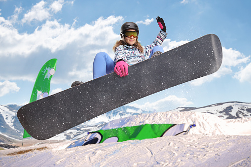 Female jumping with a snowboard at a competition on a mountain