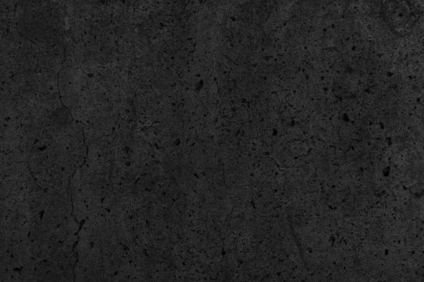 istock Old cracked black concrete wall. Dark rough cement distressed texture. Gloomy grunge textured background 1463361236
