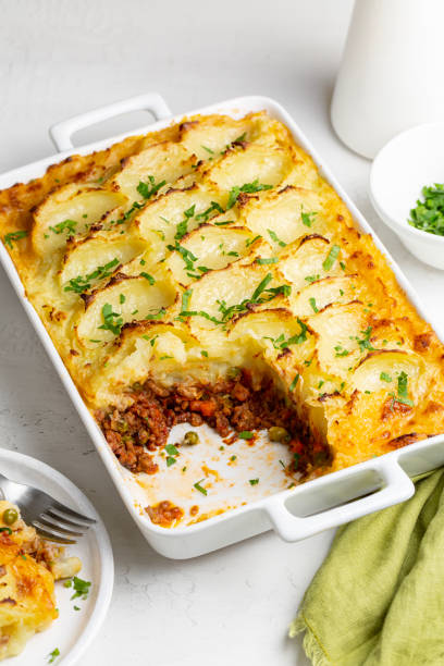 istock English Shepherd's pie, or cottage pie, or French version hachis Parmentier. Cooked minced beef meat with vegetables, green pea, carrot, onion,  topped with mashed potato with cheese and baked. Vertical image. 1463363623