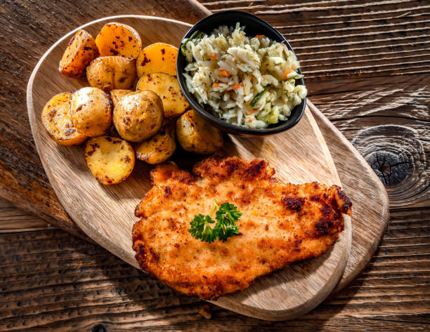 chicken cutlet coated with breadcrumbs with potatoes and cabbage - milanese imagens e fotografias de stock