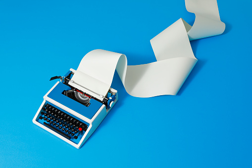 Blue typewriter of the 80s with an endless paper roll