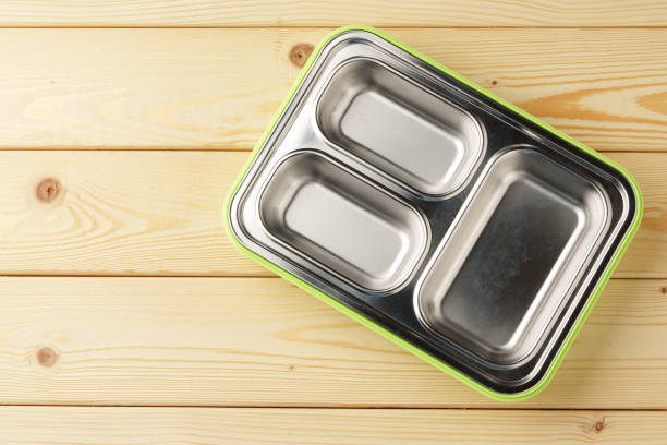 Metal lunch box with compartments on wooden background top view
