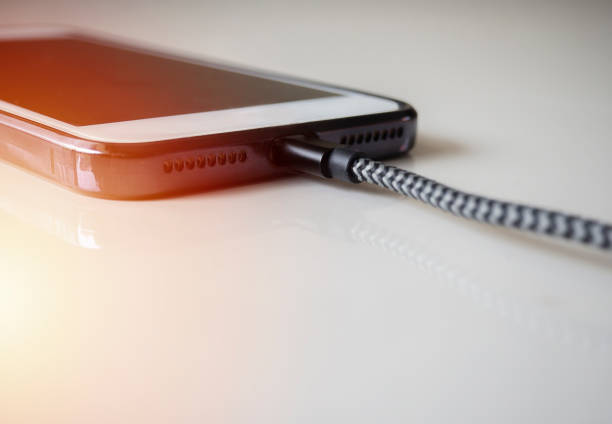 istock Smartphone connected to a usb charging cable and fast charging on beige background. 1463366865