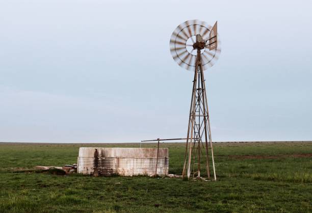 istock Windmill in a large green field under the gloomy sky 1463368911