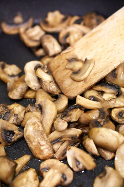 istock Closeup of a champignon mushrooms being cooked in a pan 1463370852
