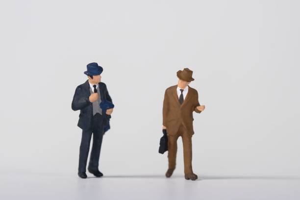 白い背景に歩きながら話すビジネスマンの置物。 - figurine small businessman discussion ストックフォトと画像