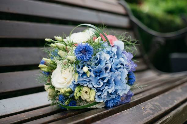 istock Flower bouquet decorated with greenery on a wooden bench. 1463371495