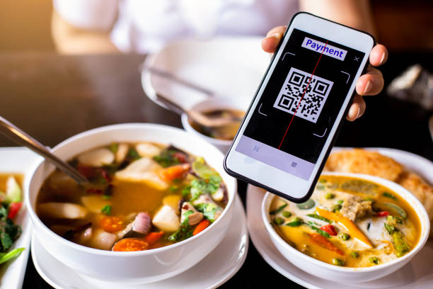 istock Customer hand using smart phone to scan QR code tag with blurry  Thai food to accepted generate digital pay without money. 1463374558