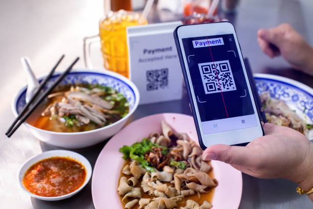 istock Customer hand using smart phone to scan QR code tag with blur  noodles or chinese food and blurry soft drik to accepted generate digital pay without money. 1463374569