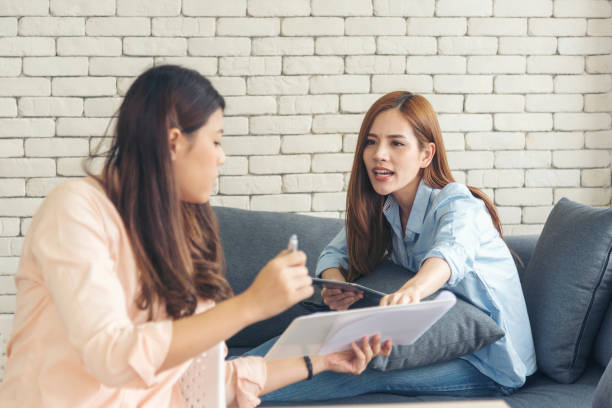 istock Two asian Female freelance reading financial graph charts Planning analyzing marketing data. Asian people team working office firm. Two businesswomen team meeting using laptop at company office desk. 1463375086