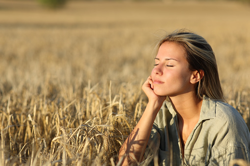 Woman in a field at sunset resting