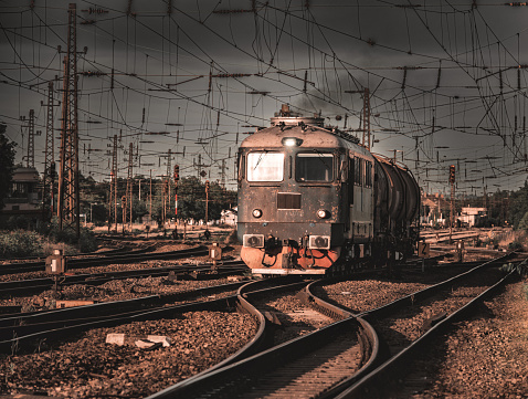 A diesel locomotive with a tank railroad car in motion at sunset, Europe, Hungary