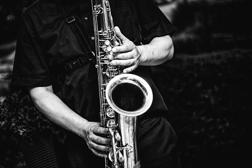 A greyscale shot of a person playing the saxophone