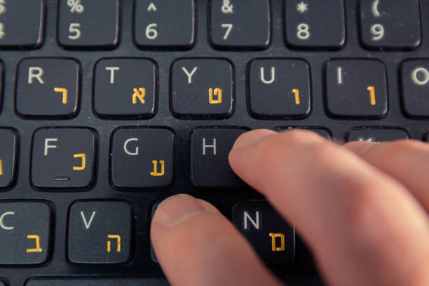 istock Man typing on a keyboard with letters in Hebrew and English 1463378620