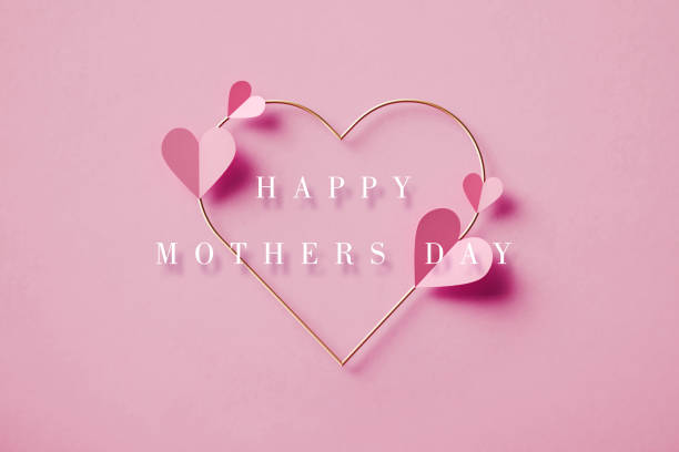 ピンクの背景に金色のハートの上にピンクのハートの形の上に幸せな母の日のメッセージ