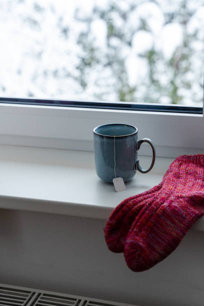 istock A cup of tea and woolen socks on a windowsill 1463380752