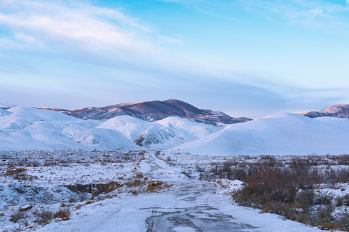 A beautiful landscape of a road to the snowy mountains - great for wallpapers