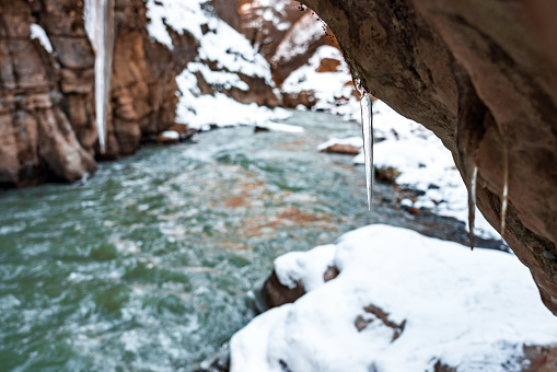 A photo of icicles in a mountain canyon and snow-covered rocks