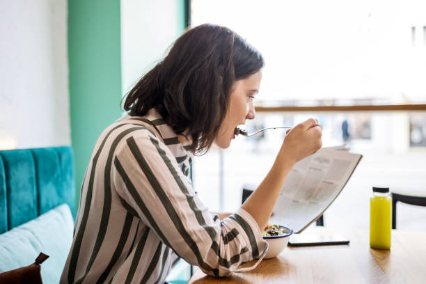 istock Attractive young woman reading magazine on a lunch break 1463382026