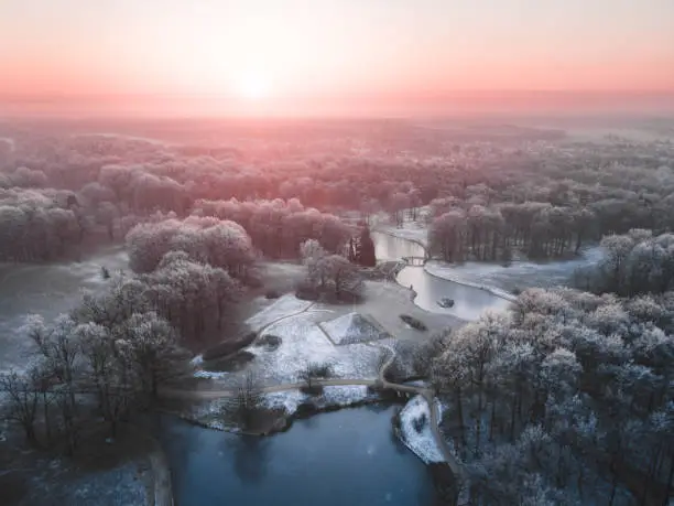 An aerial view of the Branitz park with a pyramid and lake during the wintertime in Cottbus, Germany