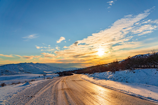 An icy slippery asphalt road at sunset in highlands in Azerbaijan