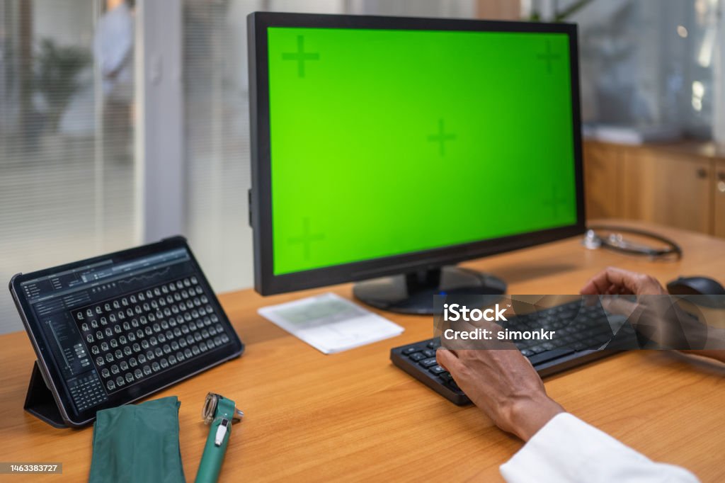 Close-up woman using computer Close-up of woman hand using computer monitor of green screen in hospital. Computer Monitor Stock Photo