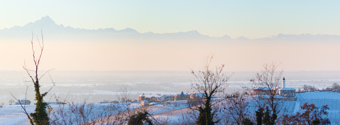 A panoramic view of mountain silhouettes over a village or a small town in winter