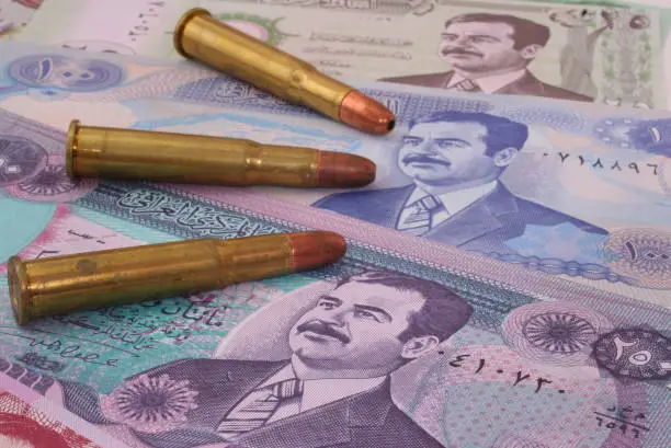 A closeup shot of an Iraqi currency with three bullets