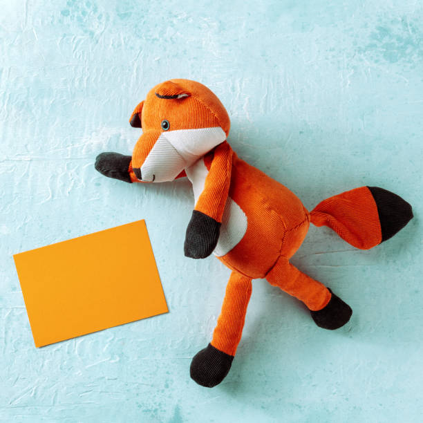istock Square mockup for an orange card with a toy fox. A greeting card or invitation 1463389260