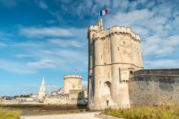 Photo of Beautiful medieval Saint Nicolas Tower of La Rochelle on a sunny day against a blue cloudy sky
