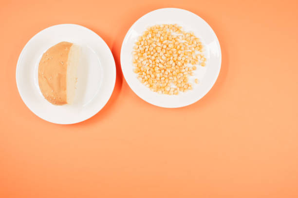 A top view shot of corn and half bread on an orange background