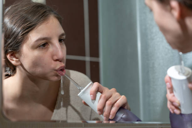 istock girl brushing her teeth with an irrigator 1463393153