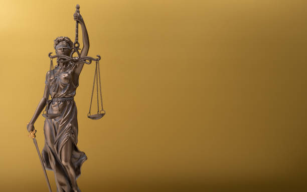 istock Statue of Lady Justice isolated on a yellow background with space 1463393421