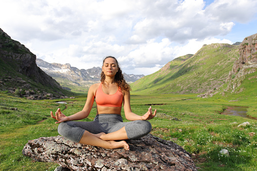 Yogi doing yoga exercise in a mountain valley