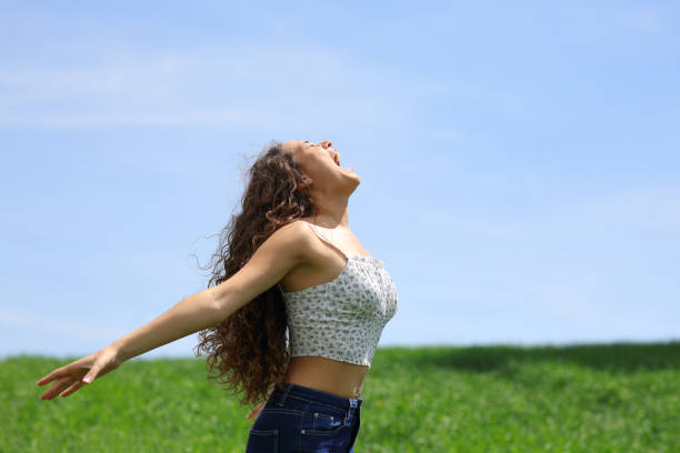 istock Happy woman screaming in a field 1463395216