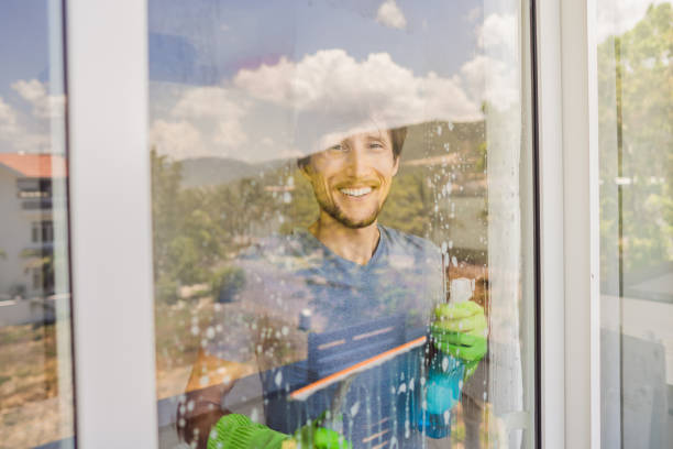 istock A young man cleaning the window with a window cleaner 1463397922